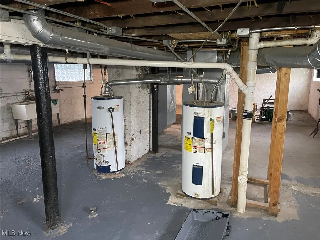 Basement featuring a sink and water heater