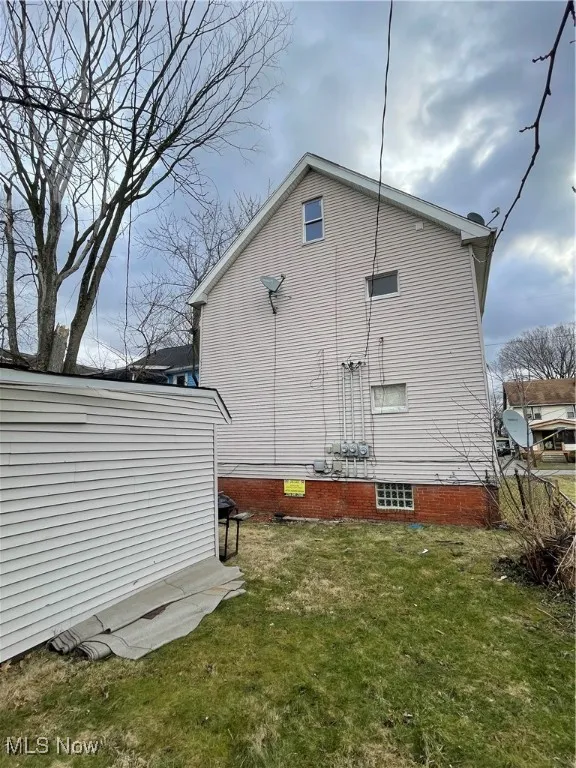 View of property exterior featuring a lawn