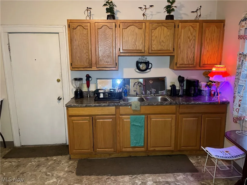 Kitchen with dark countertops, brown cabinets, and a sink