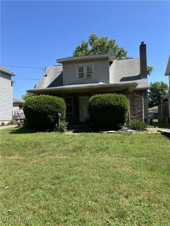 View of front of home featuring a front lawn and a chimney
