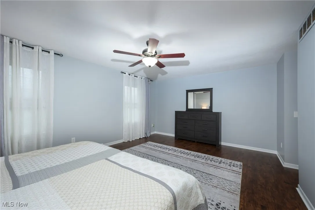 Bedroom with visible vents, baseboards, and wood finished floors