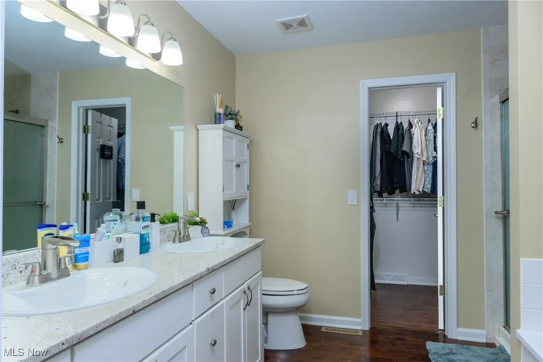 Bathroom featuring a stall shower, visible vents, and a sink