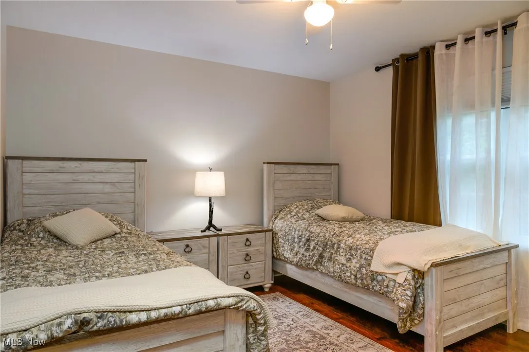 Bedroom with dark wood finished floors and a ceiling fan