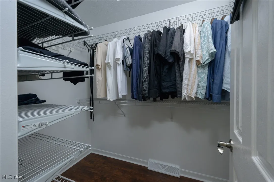 Spacious closet featuring visible vents and wood finished floors