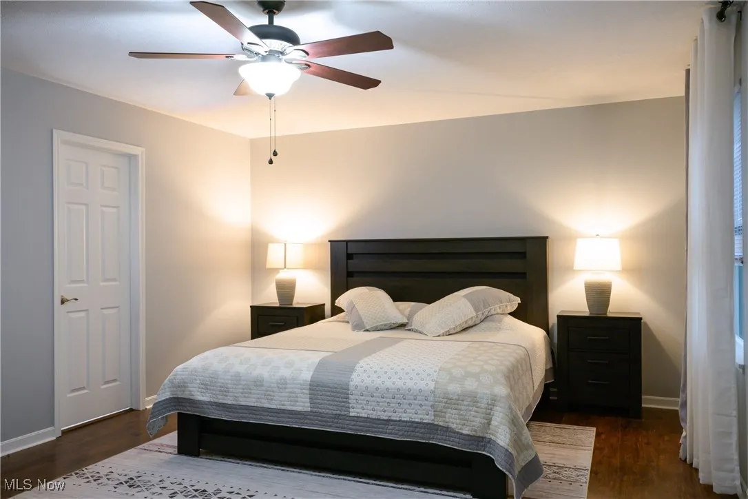Bedroom featuring wood finished floors, baseboards, and ceiling fan