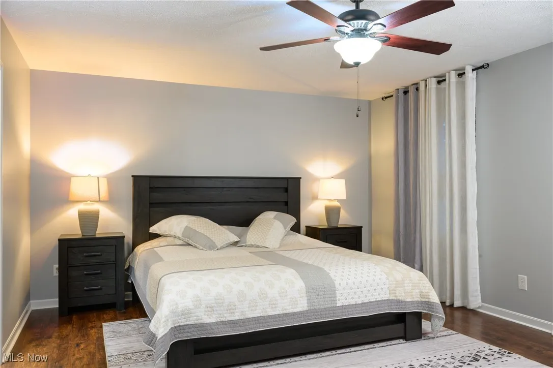 Bedroom featuring ceiling fan, baseboards, and wood finished floors