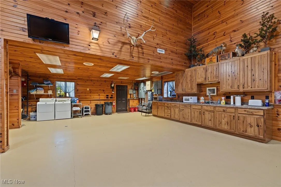 Garage with wooden walls, a sink, and separate washer and dryer