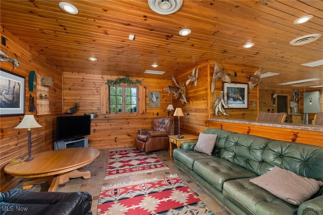 Living room with recessed lighting, wood ceiling, and wood walls