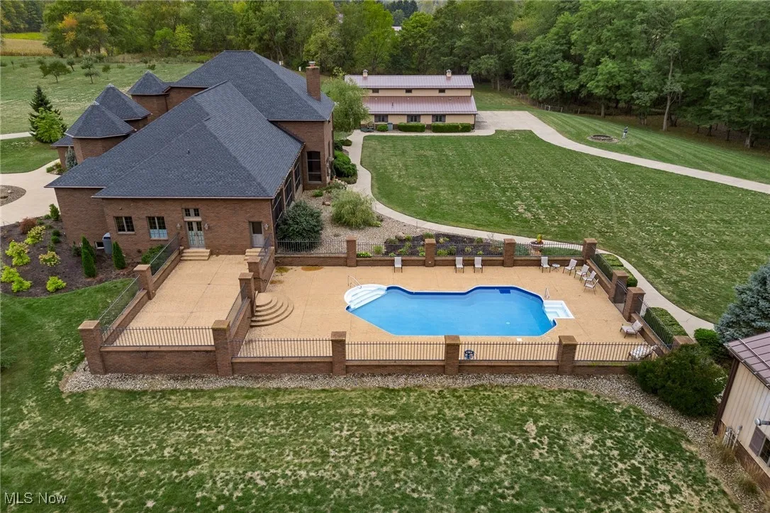 View of swimming pool featuring a lawn, a fenced backyard, a diving board, a fenced in pool, and a patio area