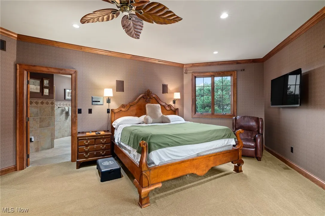 Bedroom featuring wallpapered walls, light colored carpet, and ornamental molding