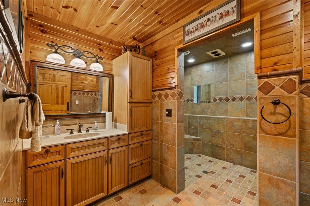 Full bath with vanity, wood ceiling, and walk in shower