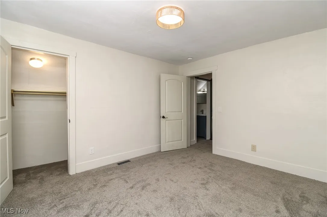 Bedroom with new carpet and neutral colors, closet.