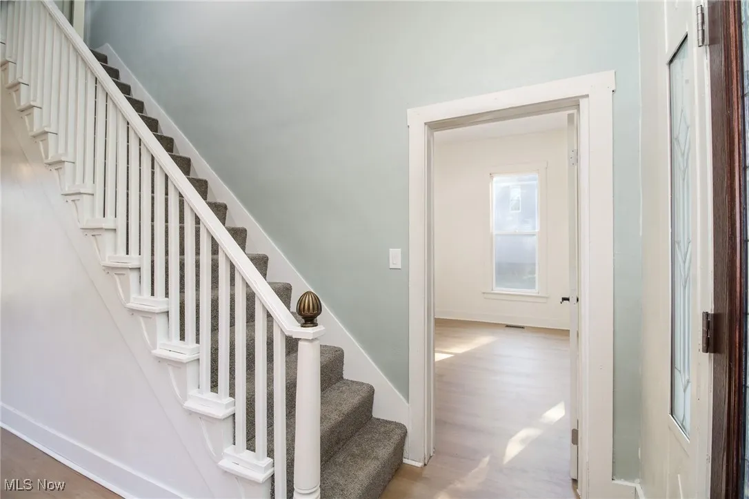 Stairs with wood finished floors and baseboards