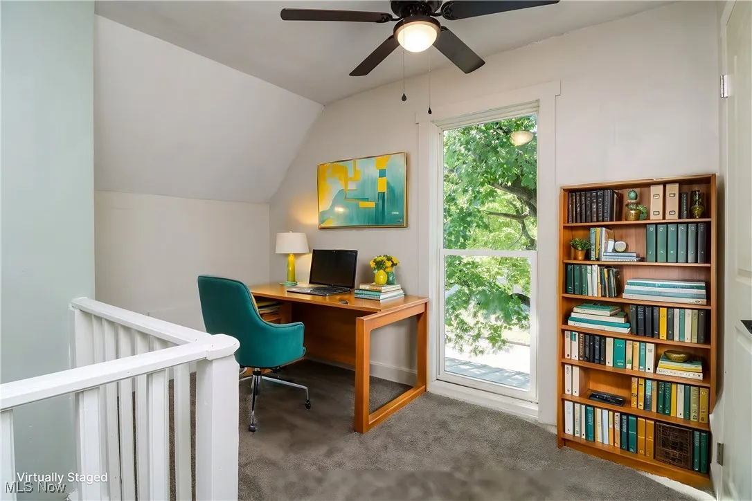 Carpeted office with lofted ceiling and a healthy amount of sunlight. Virtually Staged