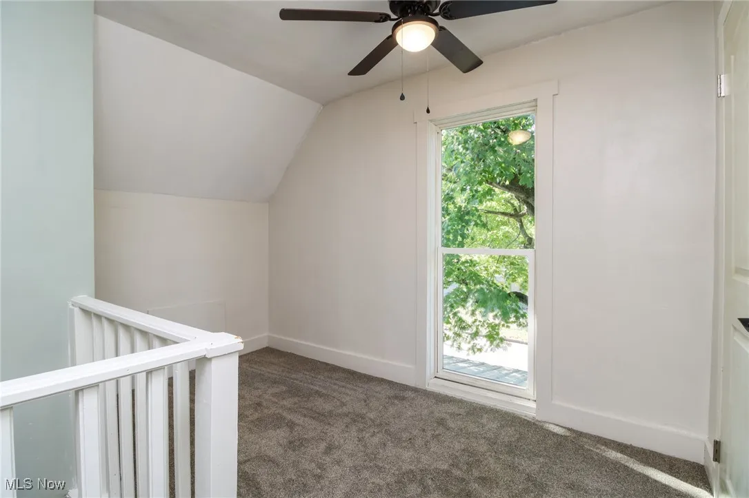 Bonus room/office space with vaulted ceiling, baseboards, and carpet floors