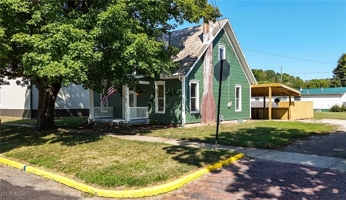 View of front of property featuring a porch and a front yard