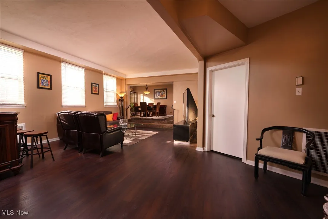 Living area featuring dark wood-style floors and baseboards
