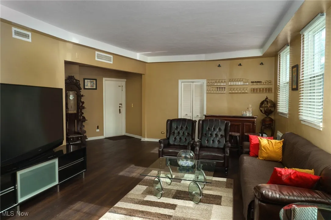 Living room featuring visible vents, baseboards, and wood finished floors