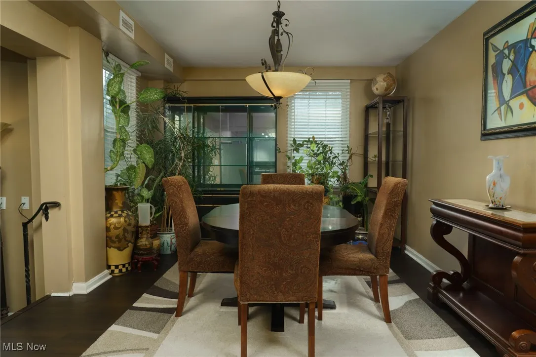 Dining area featuring visible vents, baseboards, and wood finished floors