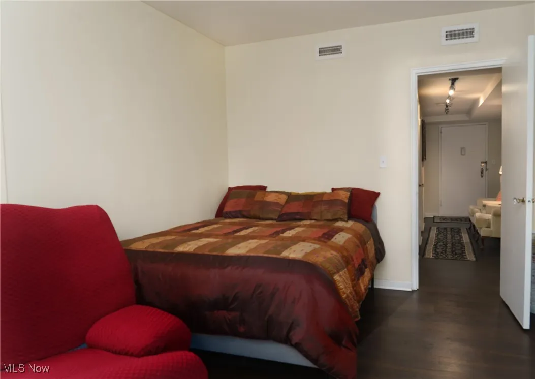Bedroom with visible vents and wood finished floors