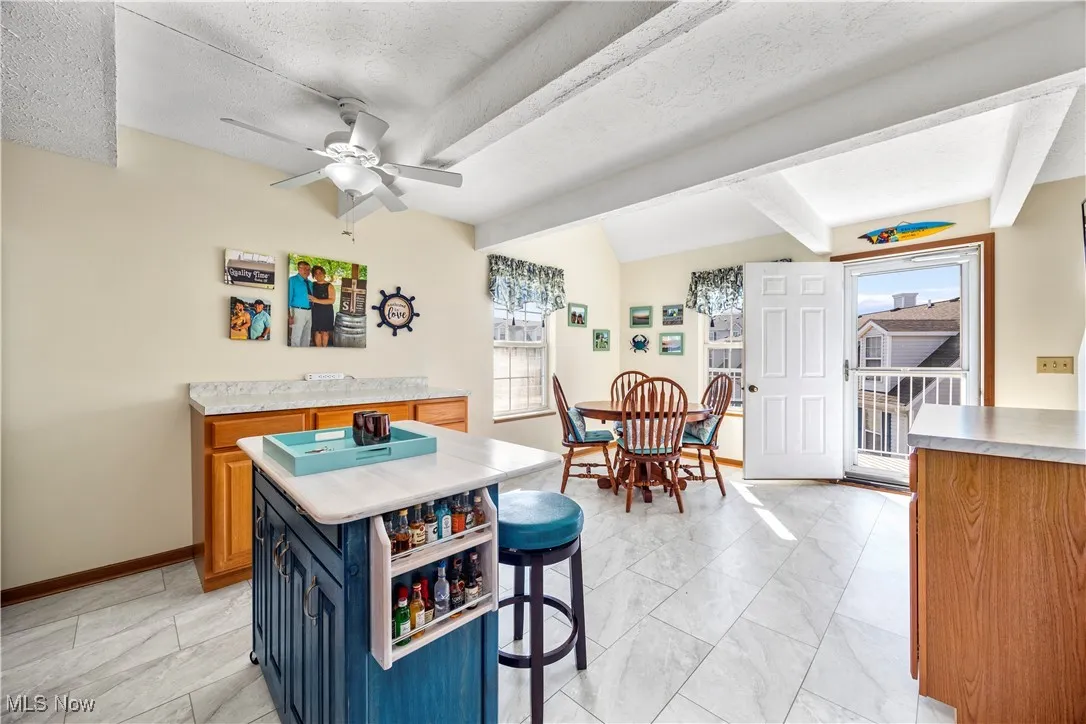 Kitchen featuring light countertops, a kitchen breakfast bar, blue cabinets, and a wealth of natural light