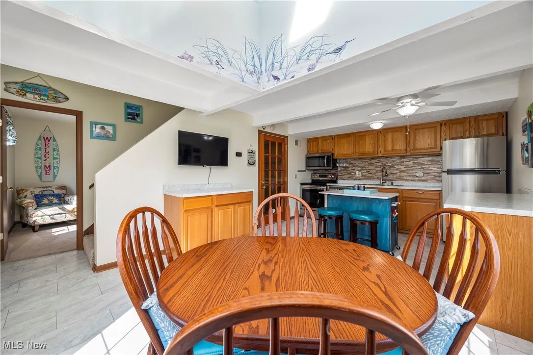 Dining space with beam ceiling and ceiling fan