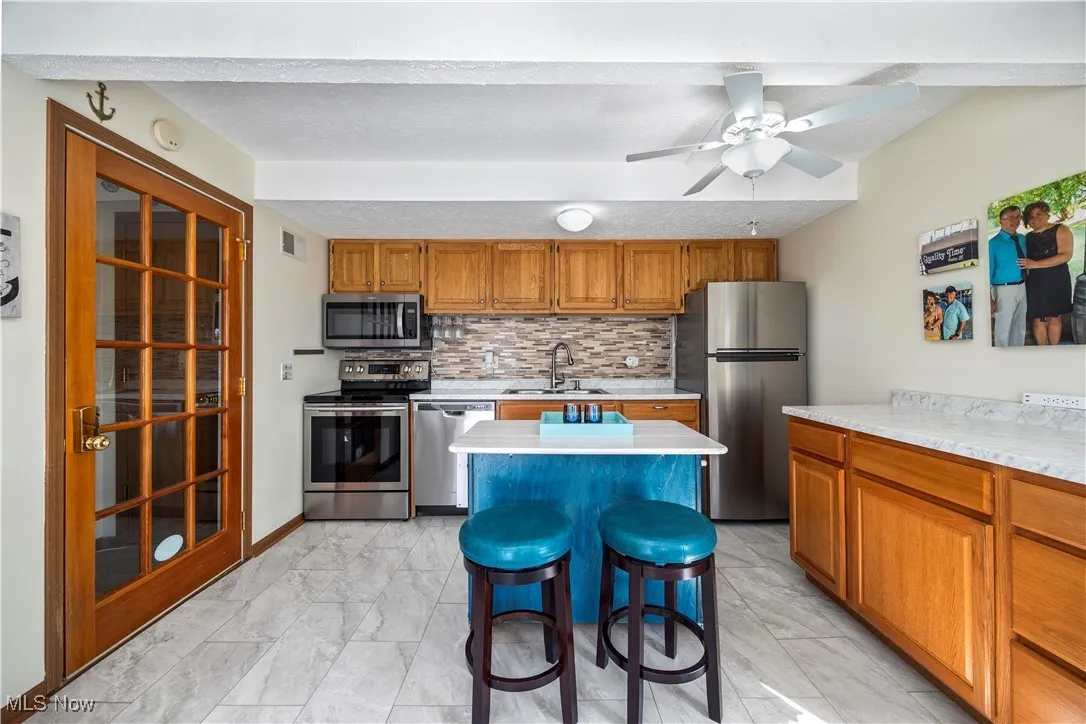 Kitchen with visible vents, marble finish floor, a sink, appliances with stainless steel finishes, and light countertops