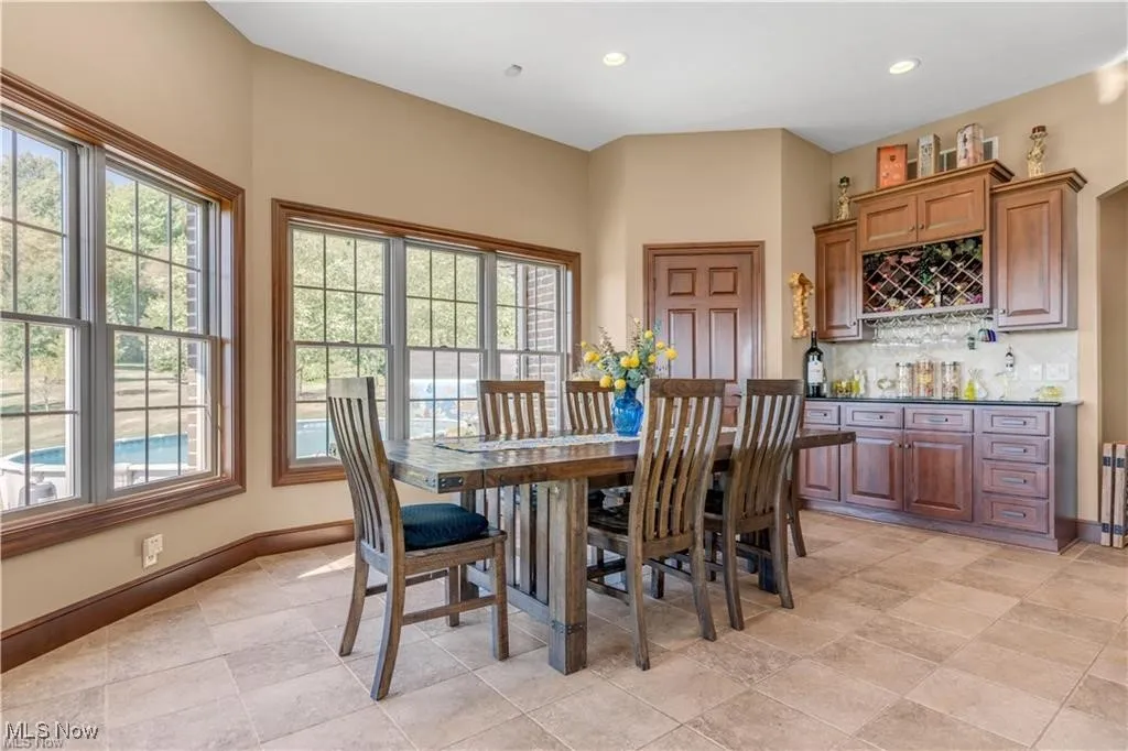 Dining space featuring a bar, recessed lighting, a healthy amount of sunlight, and baseboards