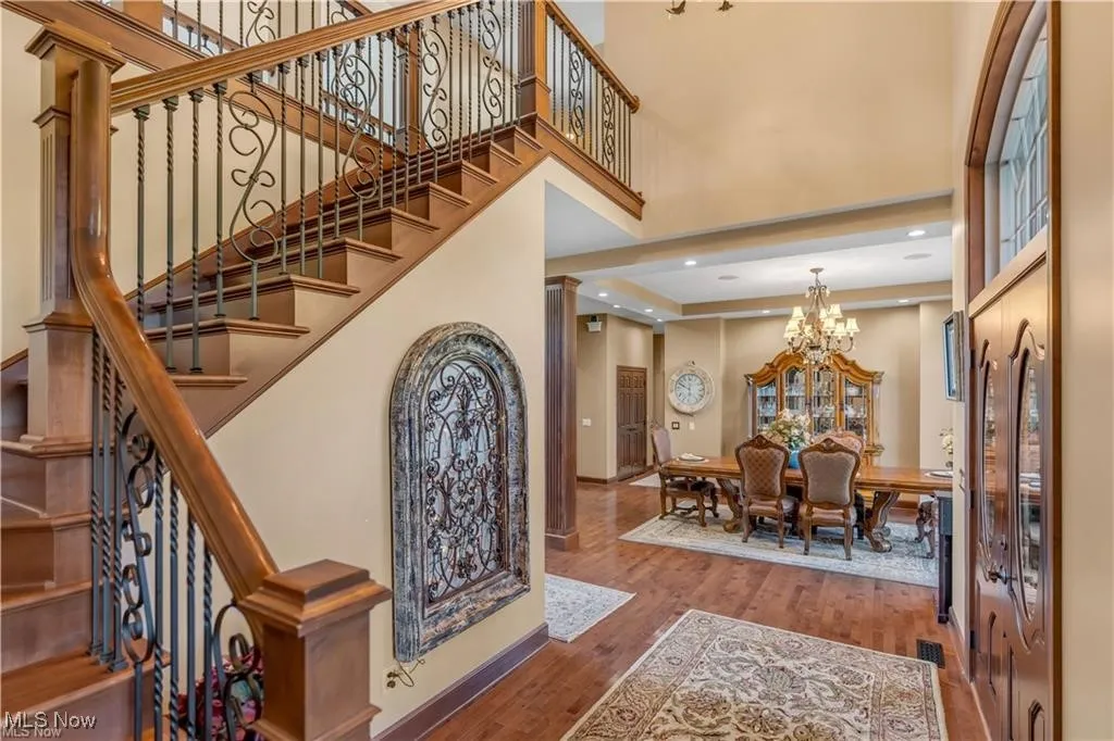 Entrance foyer with visible vents, a high ceiling, an inviting chandelier, and wood finished floors