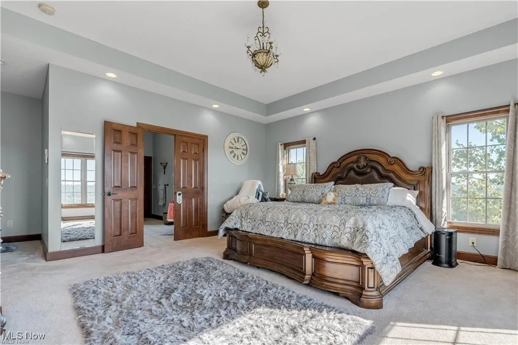 Bedroom with multiple windows, baseboards, and carpet floors