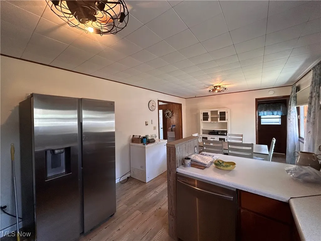 Kitchen with light countertops, wood finished floors, and stainless steel appliances