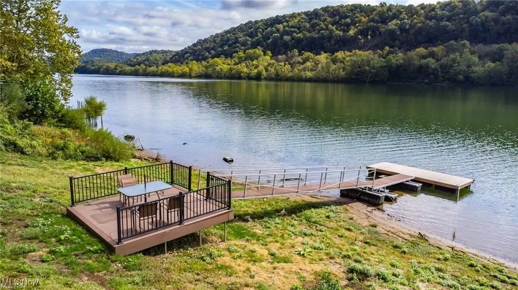 Dock area featuring a view of trees and a water view
