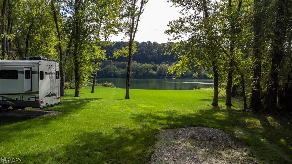 View of yard featuring a view of trees and a water view