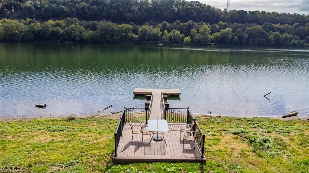 Dock area with a forest view and a water view