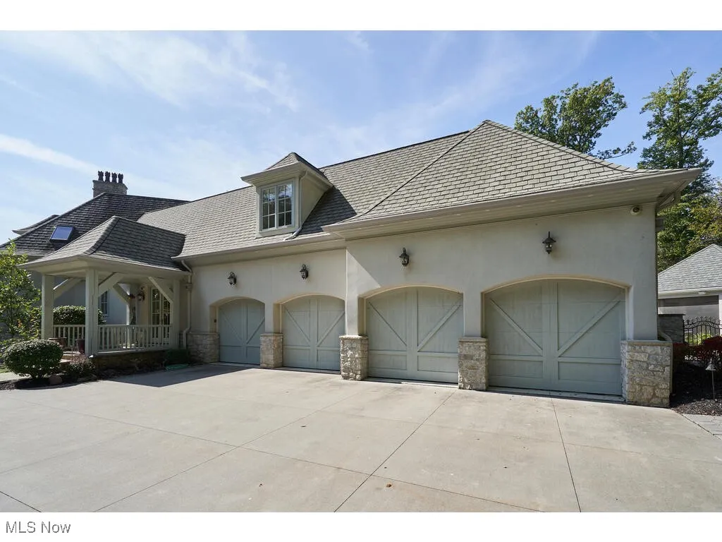 View of front of property featuring stucco siding, a garage, concrete driveway, and a chimney