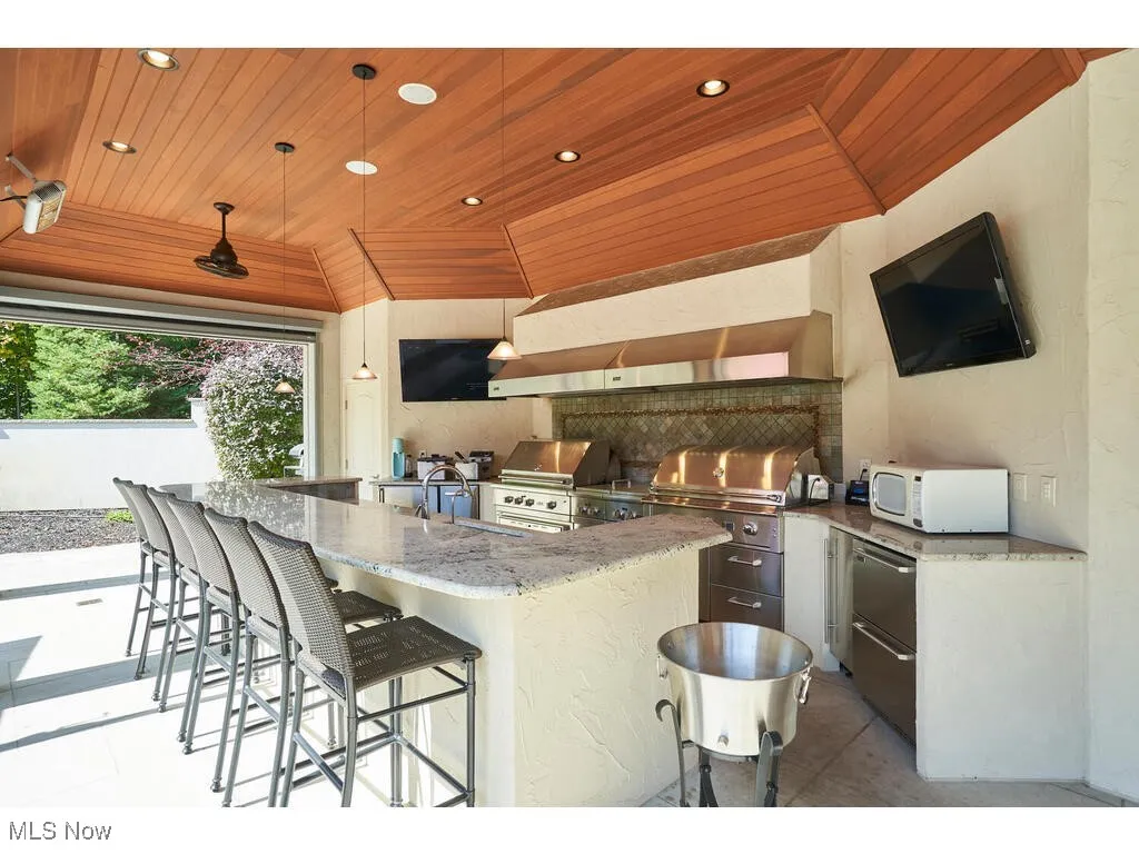 View of patio / terrace featuring a grill, exterior kitchen, outdoor wet bar, and a sink