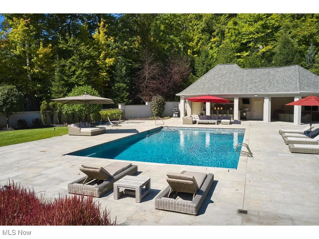 View of pool with an outbuilding, fence, an exterior structure, outdoor lounge area, and a patio area