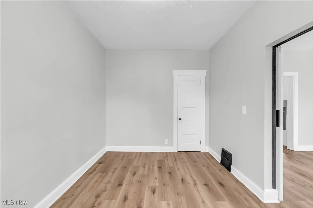 Empty room with baseboards and light wood-style flooring