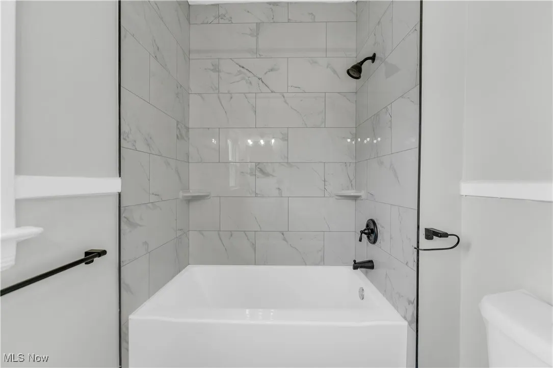 Full bathroom featuring shower / tub combination and toilet