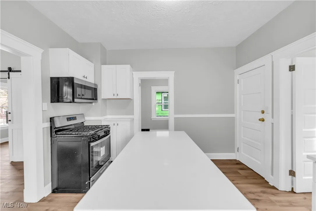 Kitchen featuring light countertops, light wood-type flooring, and stainless steel appliances