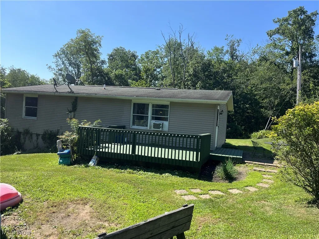 View of front of home with a front lawn and a deck