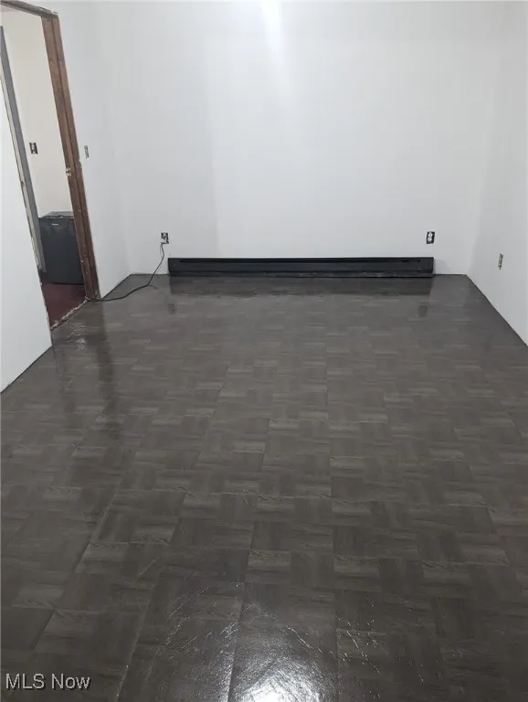 Empty room featuring a baseboard heating unit