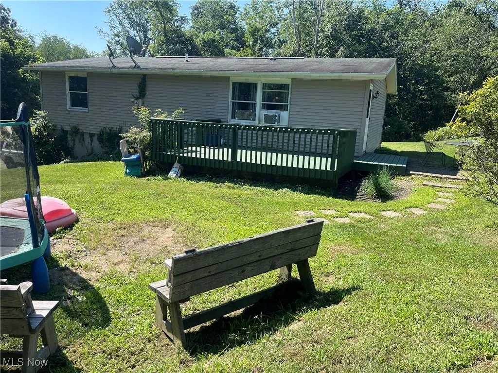 Back of property with a deck and a lawn