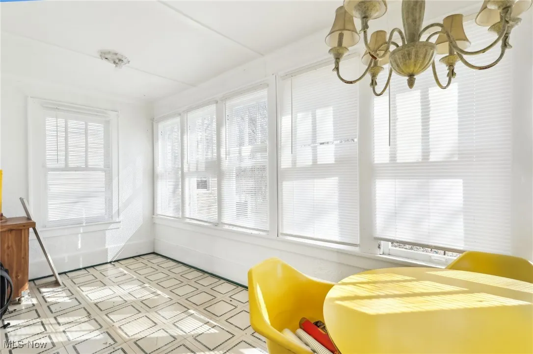 Sunroom / solarium featuring a notable chandelier