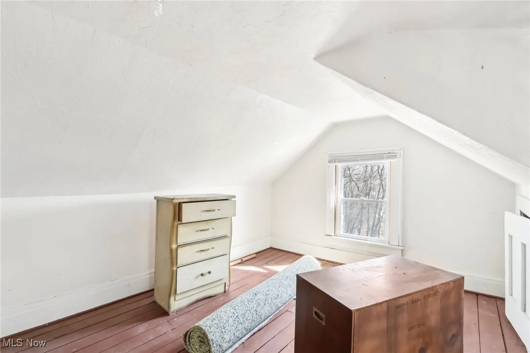 Additional living space with vaulted ceiling, baseboards, and hardwood / wood-style flooring