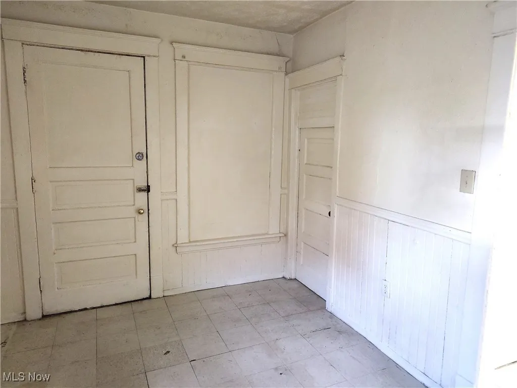 Foyer featuring a wainscoted wall and light floors