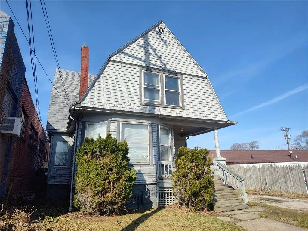 Dutch colonial with a gambrel roof, a porch, and fence