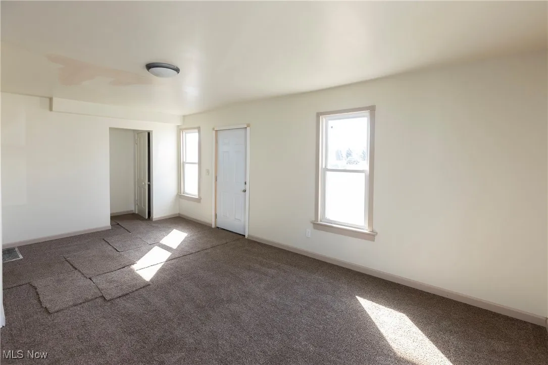 Spare room with plenty of natural light, carpet flooring, and baseboards