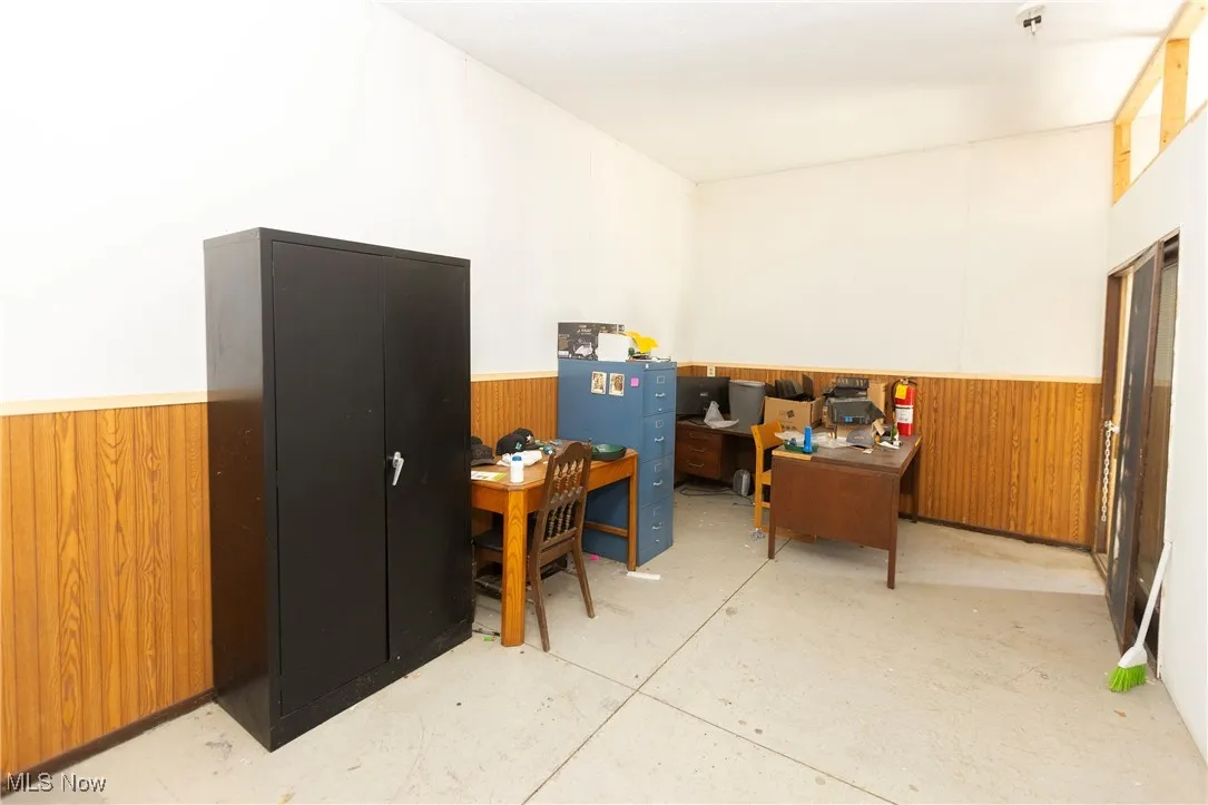 Office featuring a wainscoted wall and wooden walls