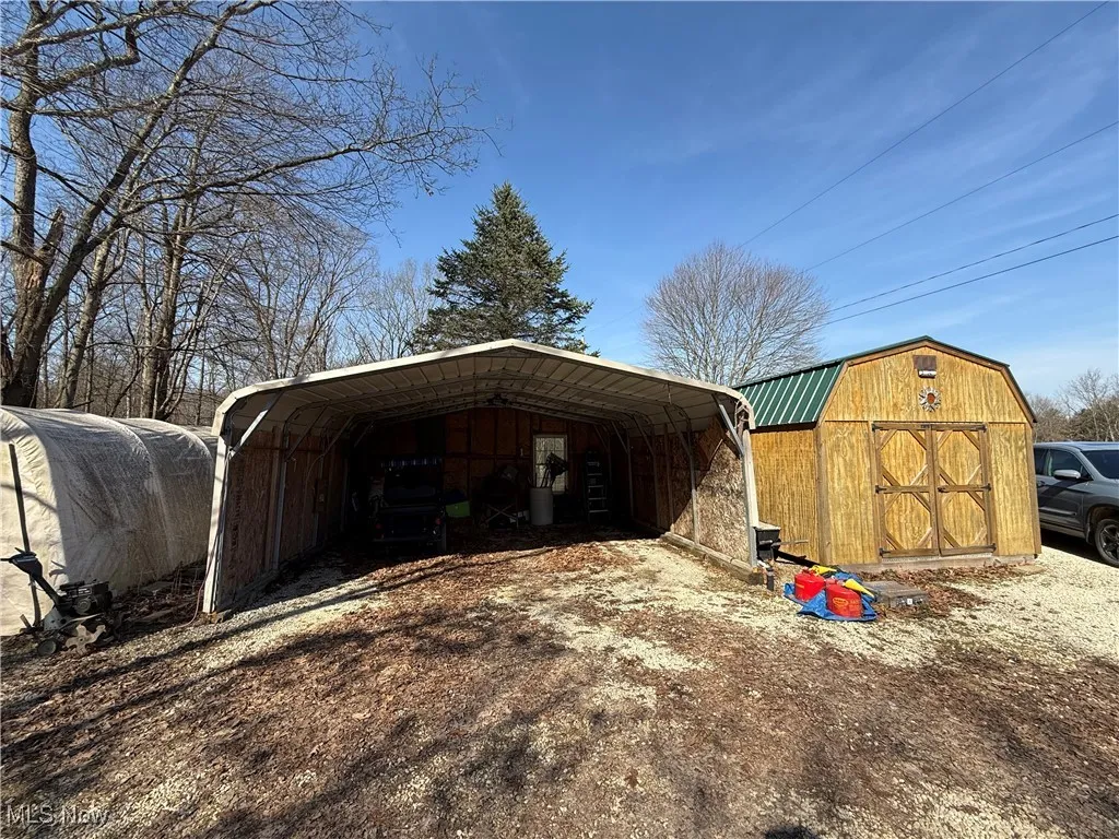 View of shed featuring a carport and driveway